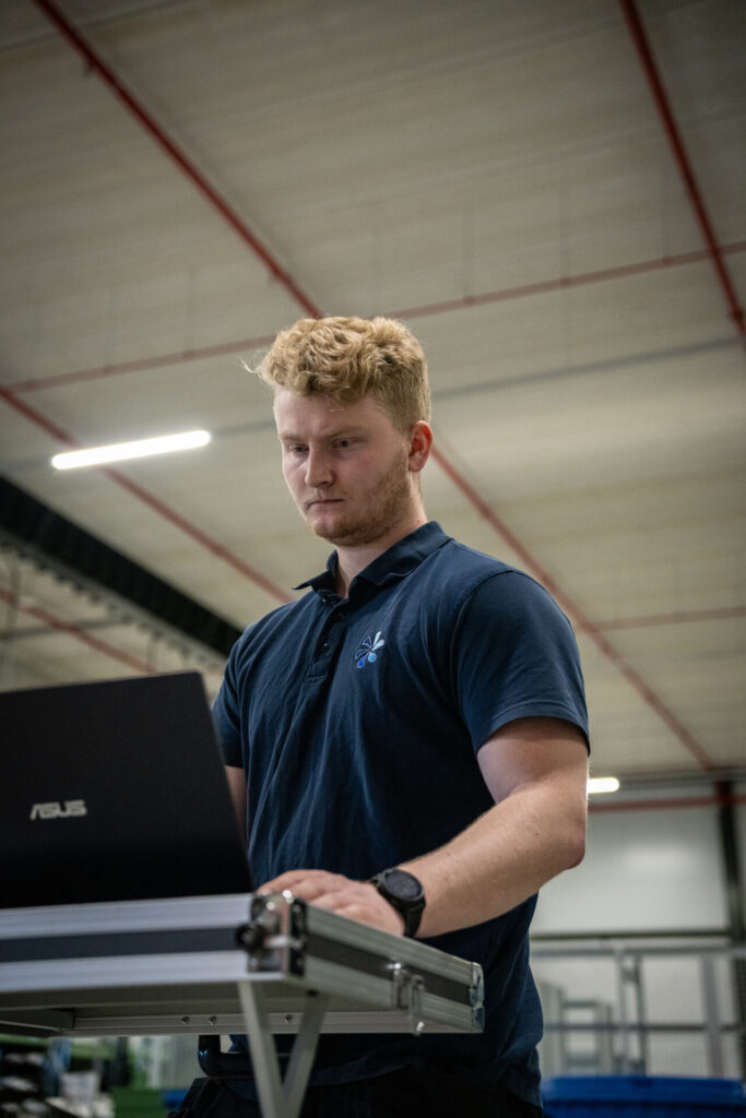 Technicus analyseert meetgegevens van luchtdichtheidsmeting op laptop in industriële omgeving