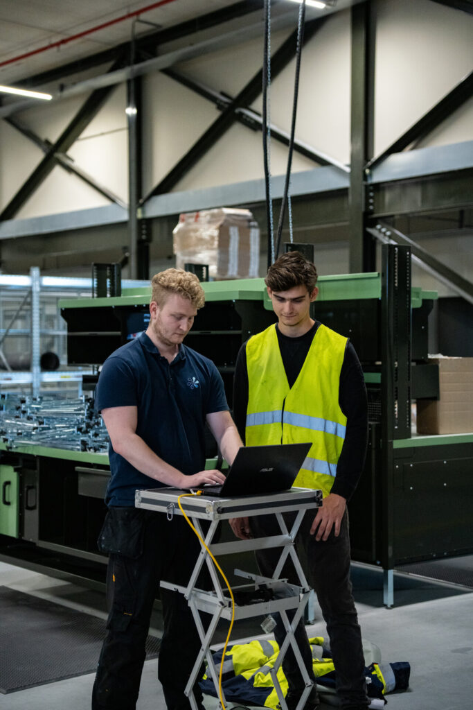 Technici analyseren luchtdichtheidsmeting op locatie met meetapparatuur in industriële omgeving