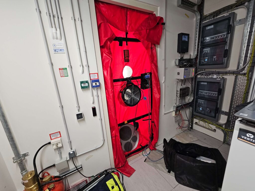 BlowerDoor test in technische ruimte met meetapparatuur voor luchtdichtheid en brandveiligheid controle door Blowertechniek
