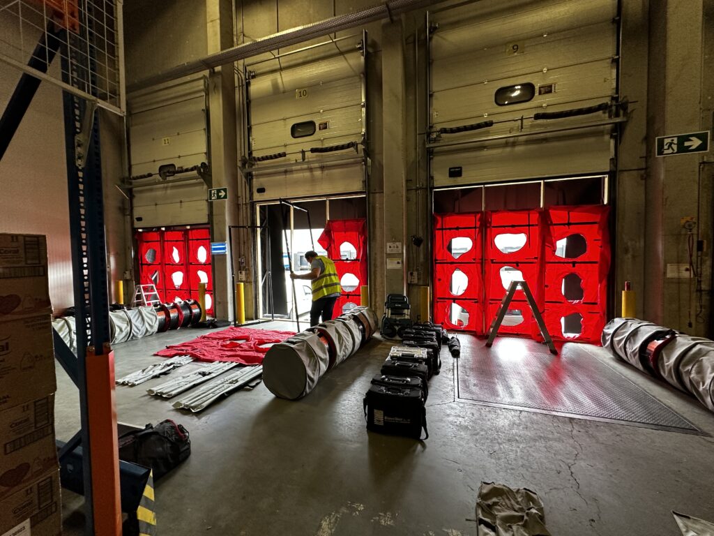 Grote luchtdichtheidstest met multi-fan BlowerDoor opstelling in logistiek magazijn waarbij meerdere deuropeningen gelijktijdig worden getest met apparatuur van Blowertechnic