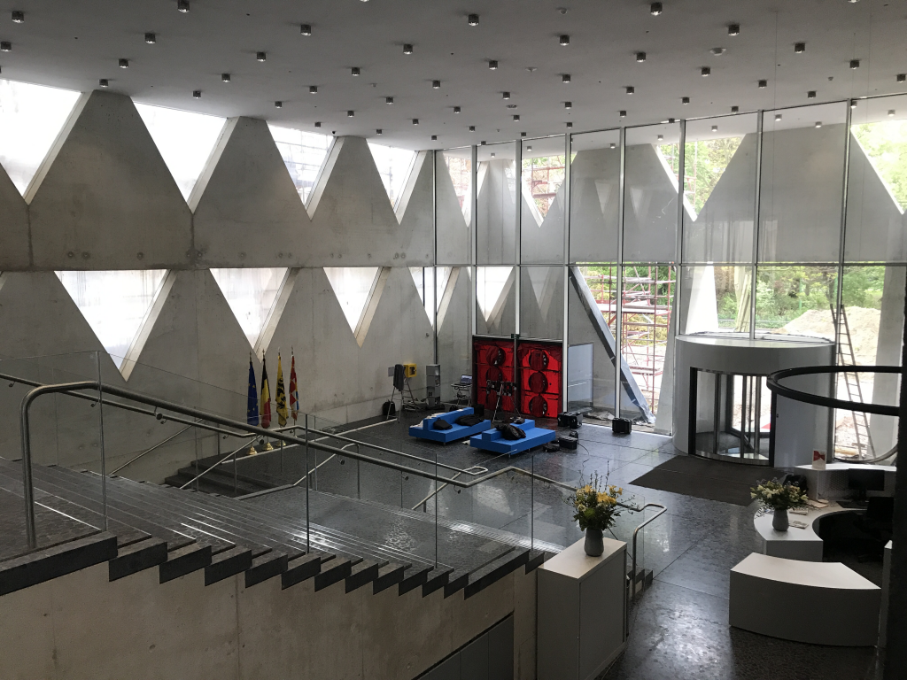 Grote moderne entreehal met glazen gevel en blowerdoor testopstelling, ingericht voor luchtdichtheidsmetingen in een representatief gebouw.