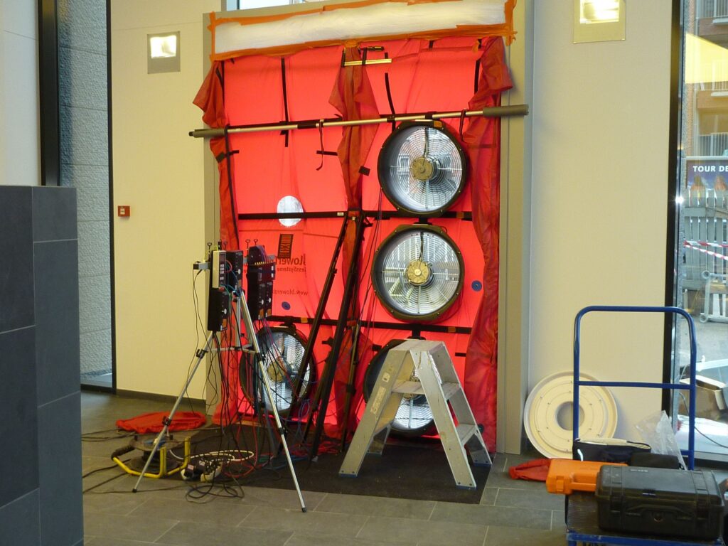 BlowerDoor multi-fan luchtdichtheidstest met uitgebreide meetopstelling en sensoren voor analyse van luchtlekken in utiliteitsgebouw door Blowertechnic