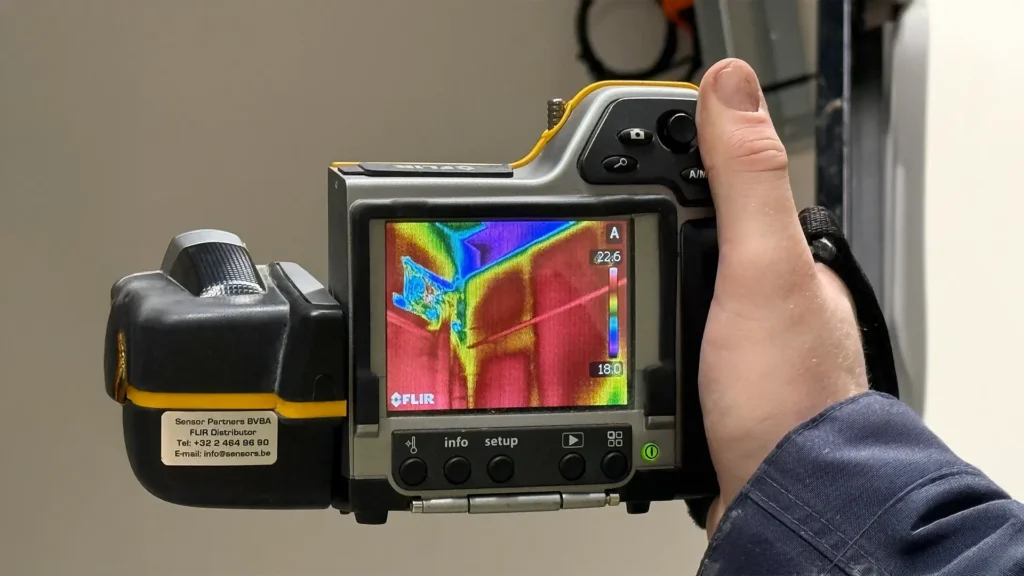 Thermografische camera in gebruik die temperatuurverschillen bij een constructie detail zichtbaar maakt, voor het opsporen van luchtlekken en koudebruggen.